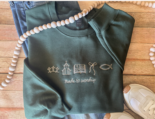 Green Christian sweatshirt with text and symbols on a wooden surface